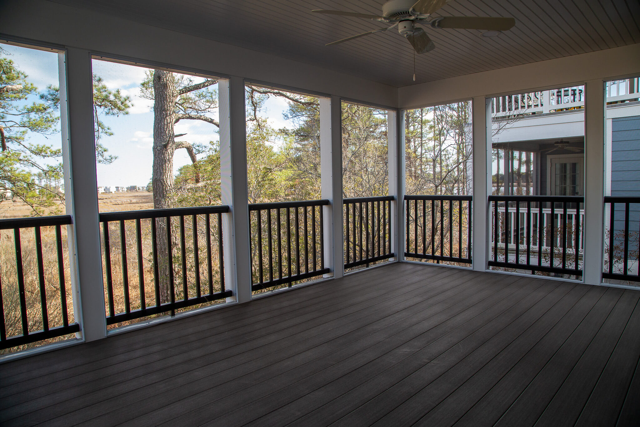 Kent Sunroom Renovation in Bethany Beach DE with Storm Door, Dark Floor Tiles, Wood Bench Seat and Light Sea Foam Wall Paint