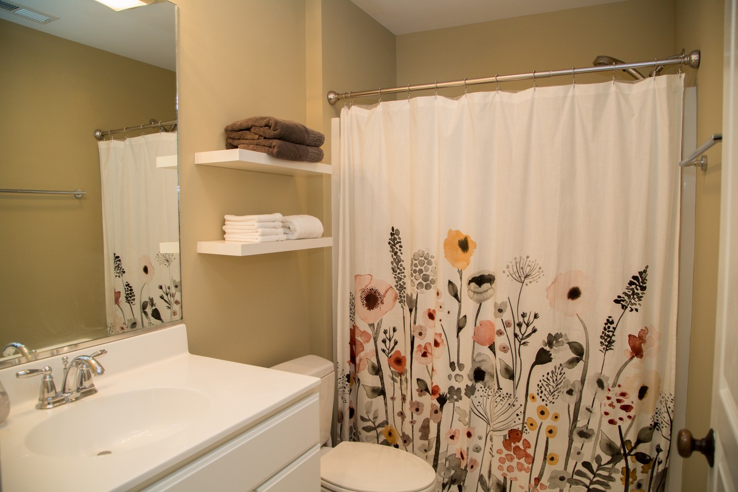Bathroom with Beige Wall Paint, White Vanity and Flower Shower Curtain