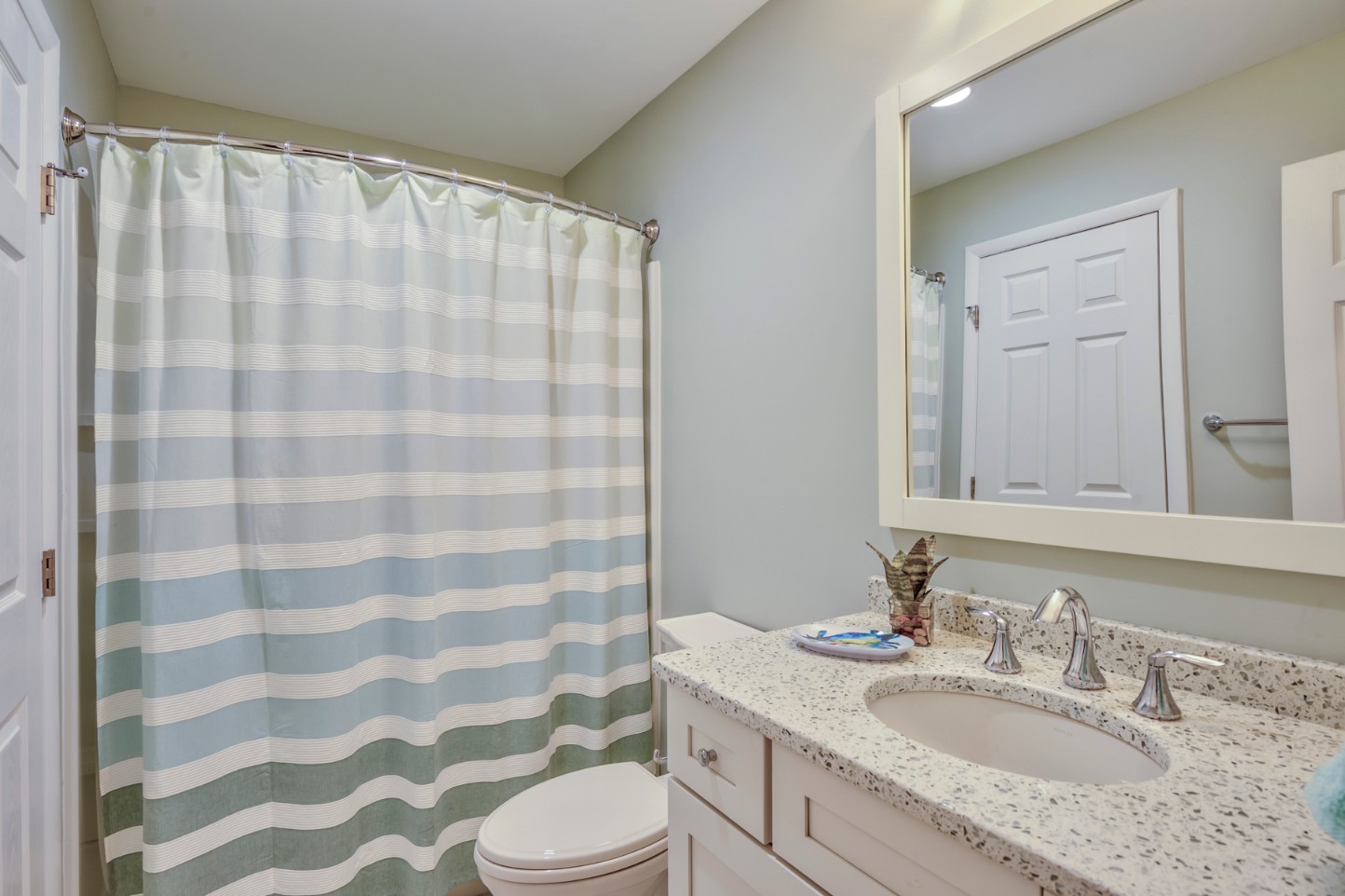 Canal Way Renovation in Bethany Beach DE - Bathroom with Shower Curtain and White Rectangular Mirror