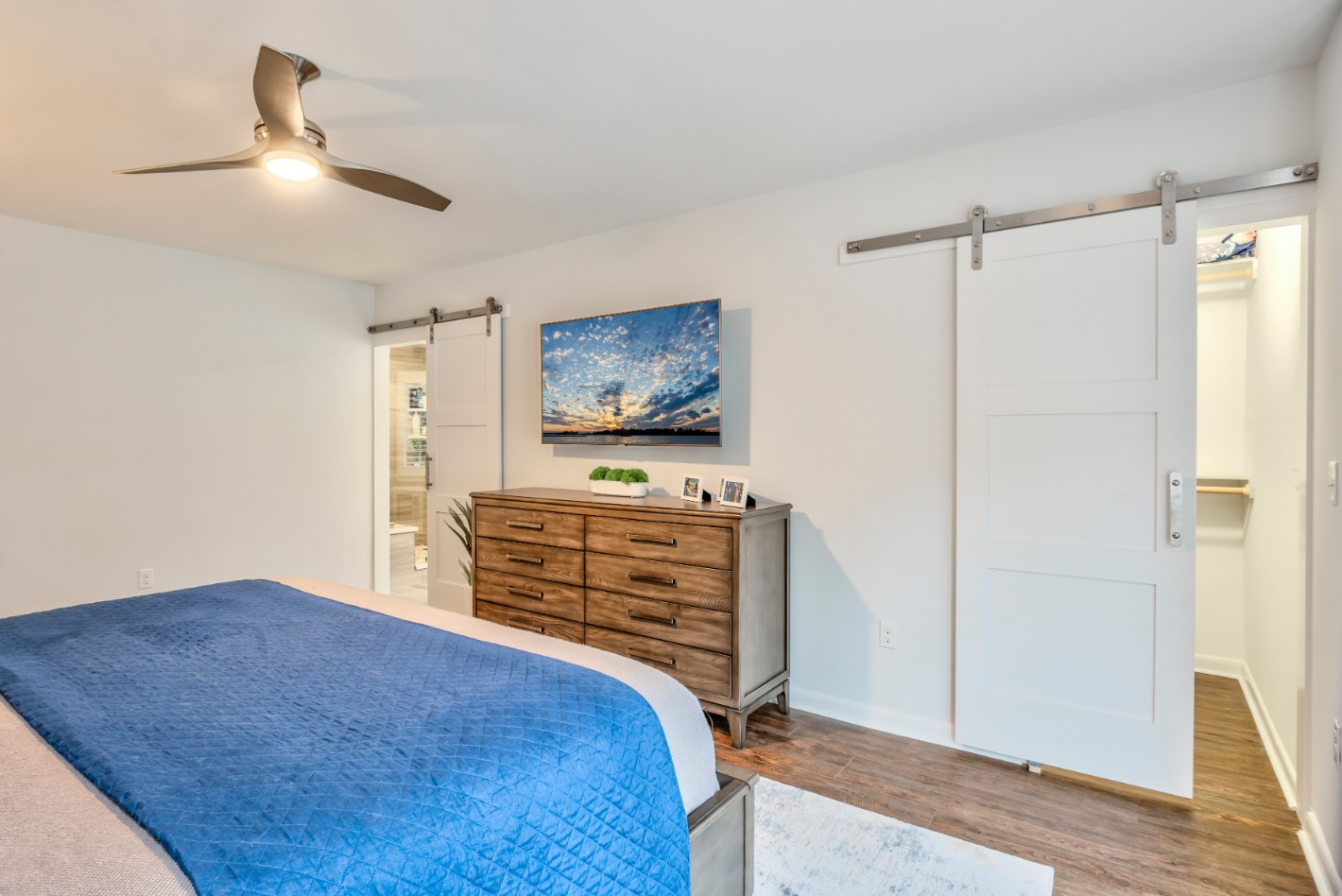 Canal Way Renovation in Bethany Beach DE - Bedroom with White Wall Paint and Two Flat Rail Sliding Barn Doors