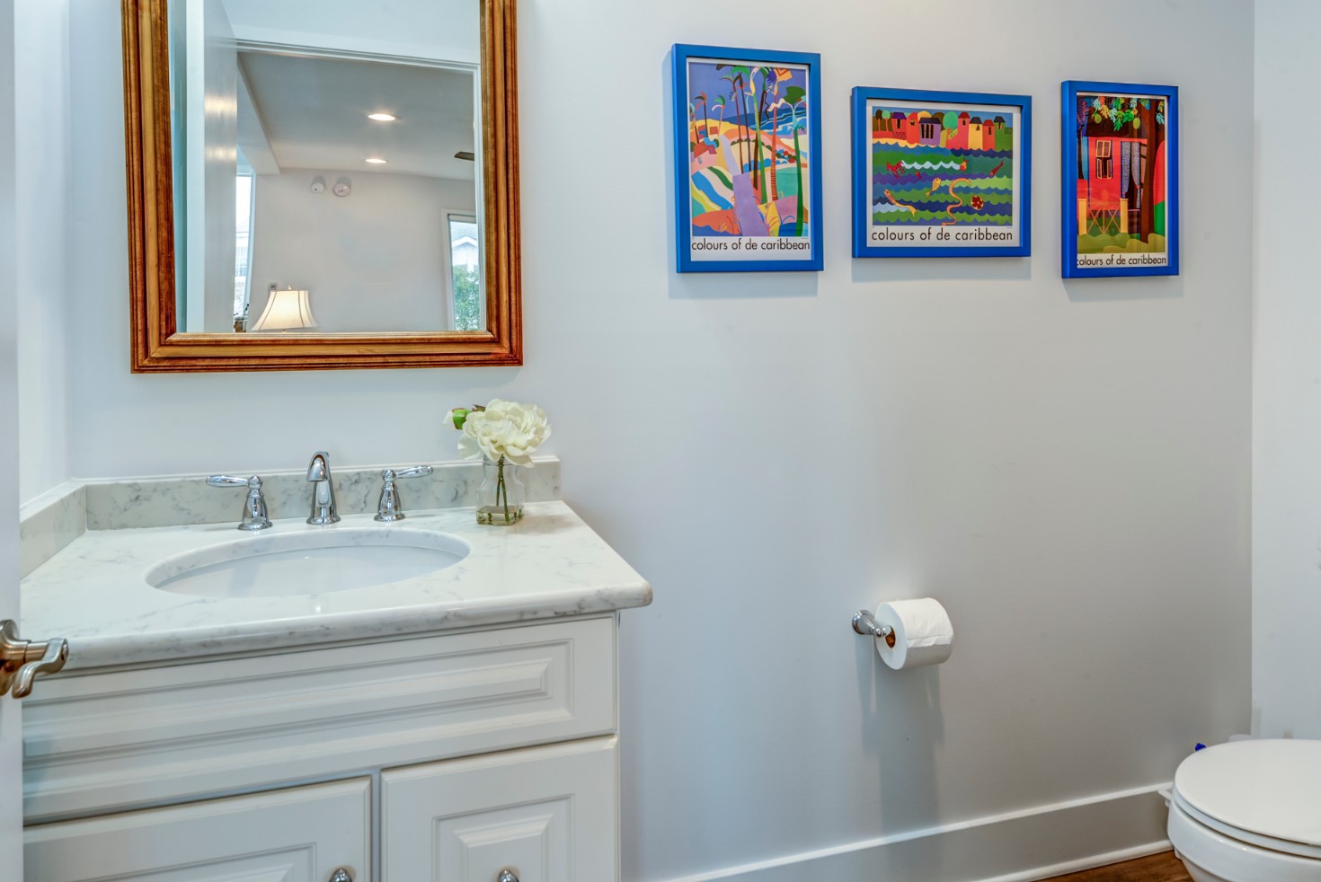 Cotton Patch Hills Renovation in Bethany Beach DE - Bathroom with Mirror with Wooden Frame and Three Framed Posters