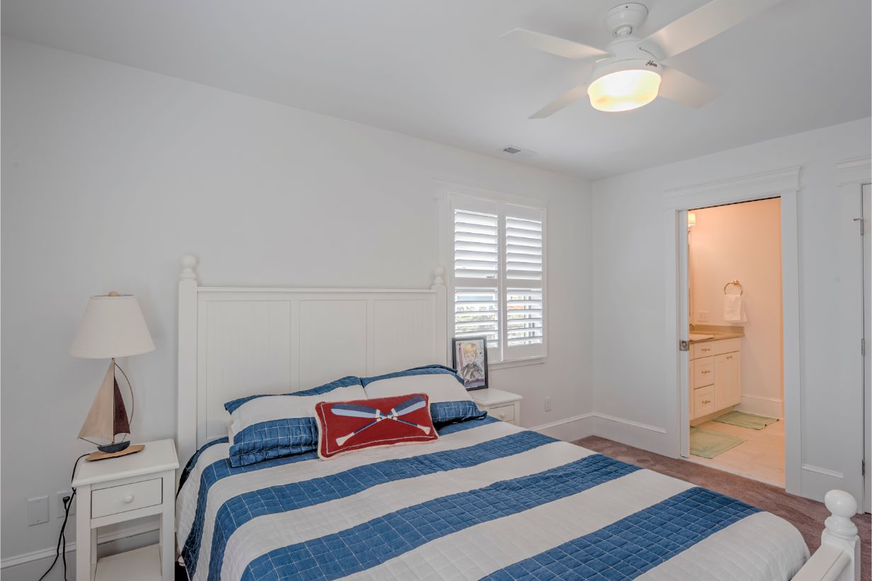 Renovation in Dune Road, Bethany Beach DE - Bedroom with White and Blue Striped Bed Cover and Night Lamp with Sailboat