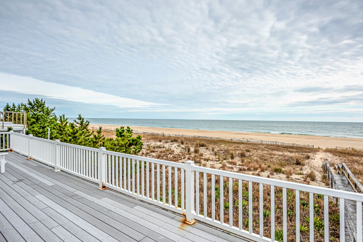 Deck with White Railing and Beach View