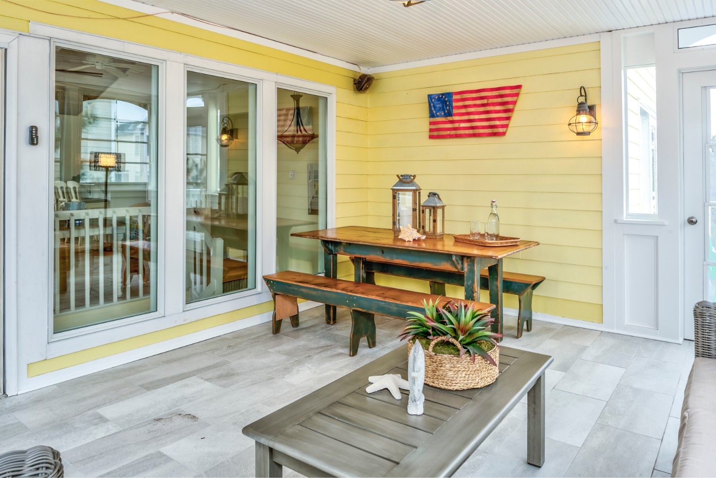 Indian Street Sunroom in Bethany Beach DE with Yellow Siding and Wooden Table and Benches