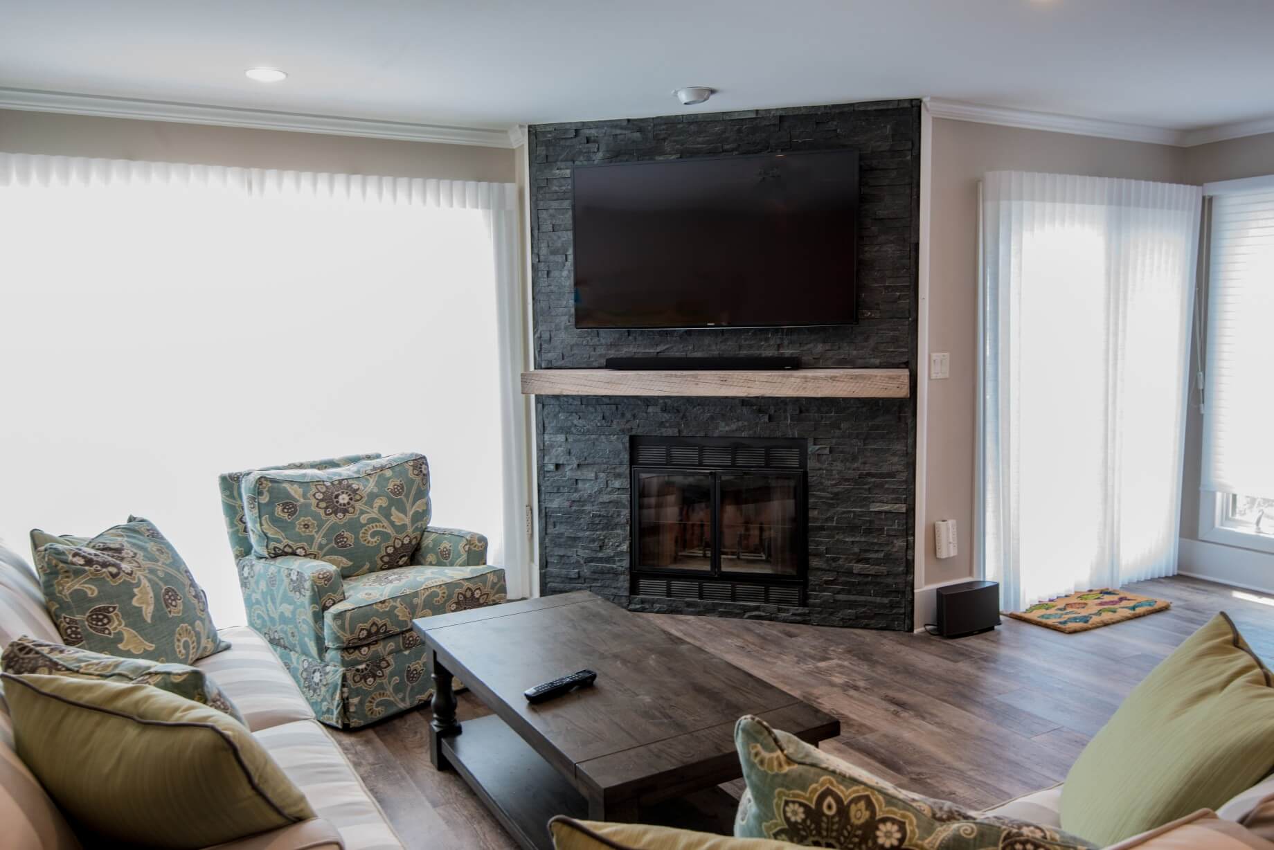 Kings Grant Renovation Vol.2 with Wall Mount TV Above Dark Stone Fireplace, Hardwood Flooring and Dark Wood Coffee Table