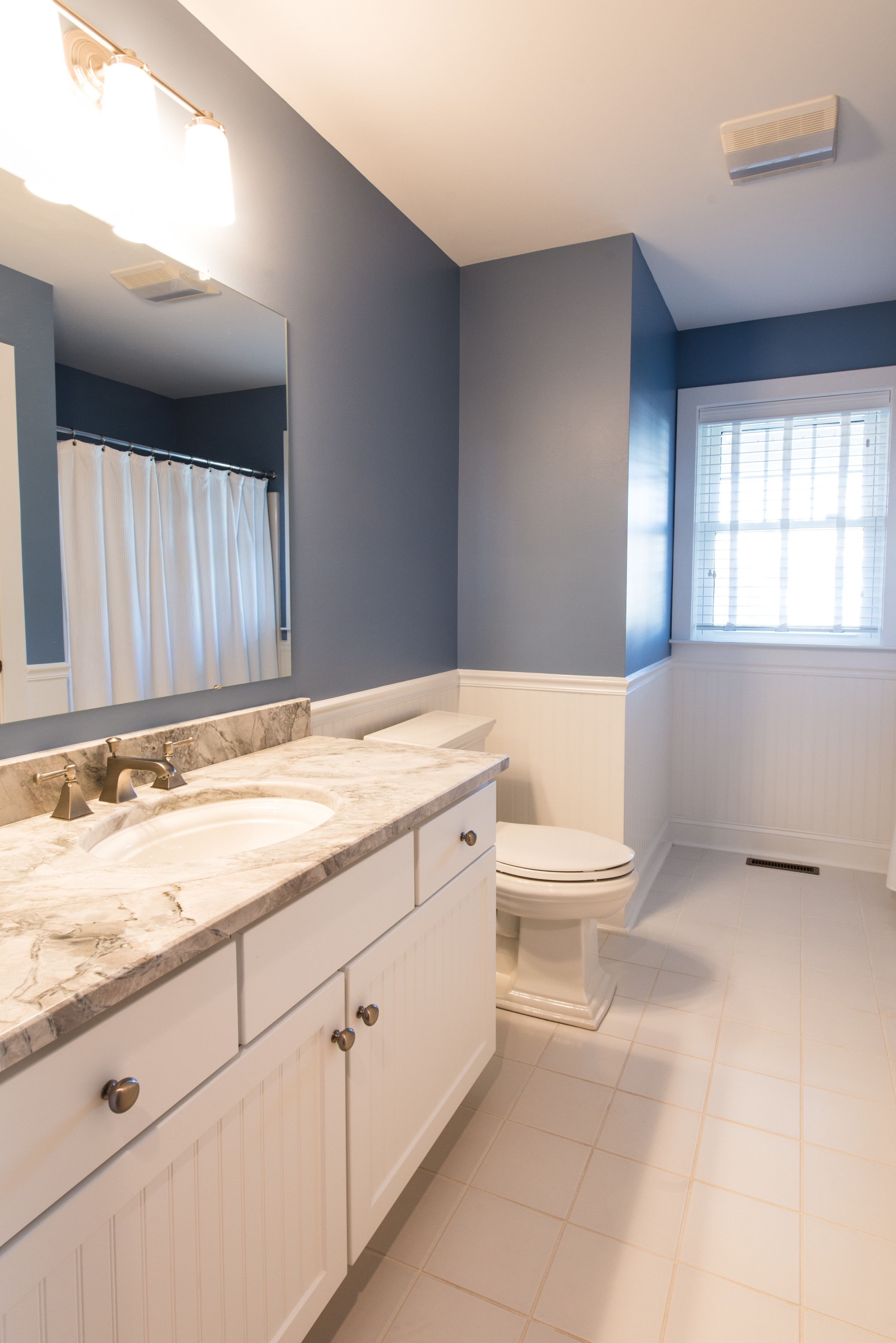 Bathroom Remodel in Ocean Ridge, Bethany Beach DE with White Floor Tiles, Memoirs Elongated Toilet and White Wood Vanity
