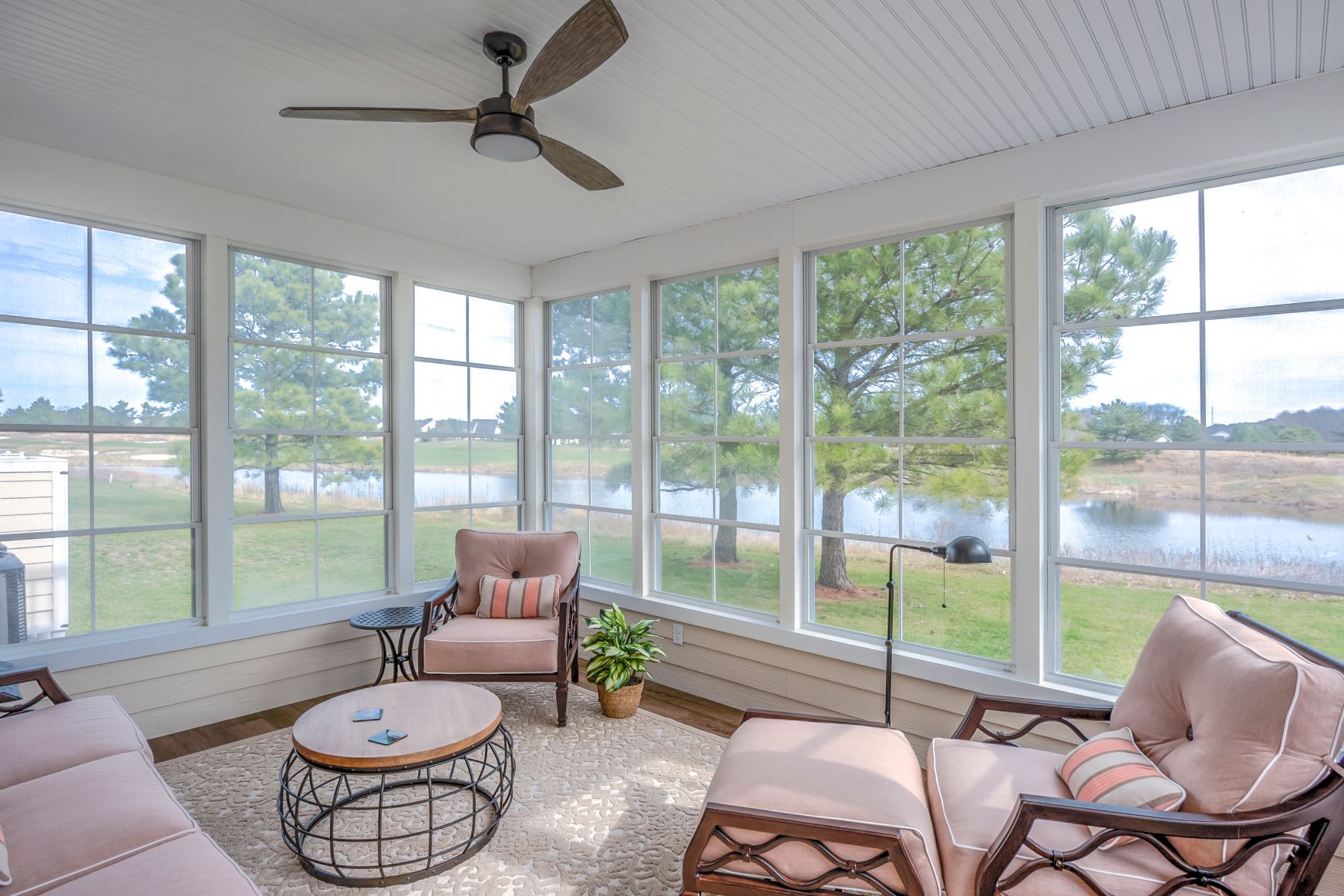 October Glory Exterior in Ocean View DE - Sunroom with Beige Soft Furniture and Vertical Sliding Windows