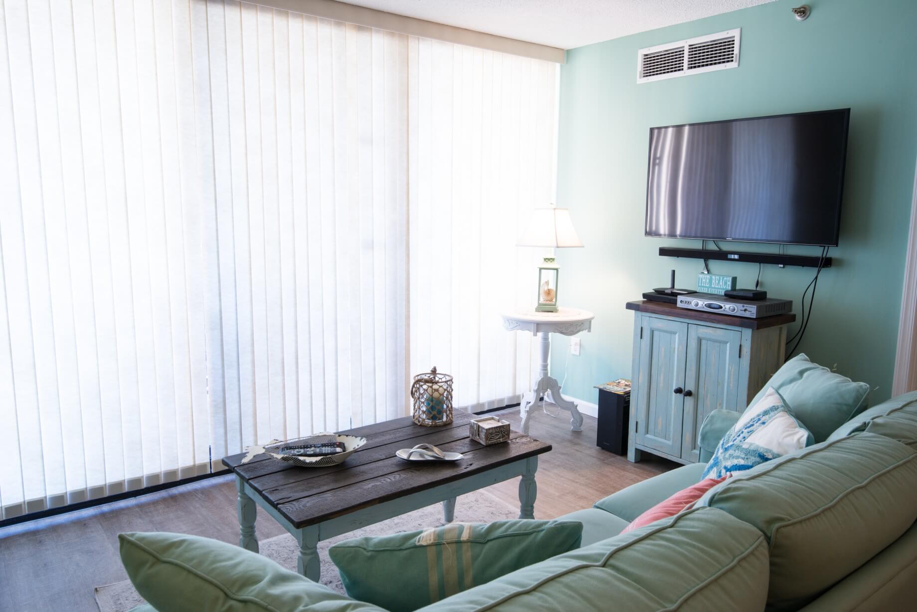 Sea Colony Condo Renovation Bethany Beach, DE Living Room with Turquoise Color Large Sofa and Dark Wood Floor