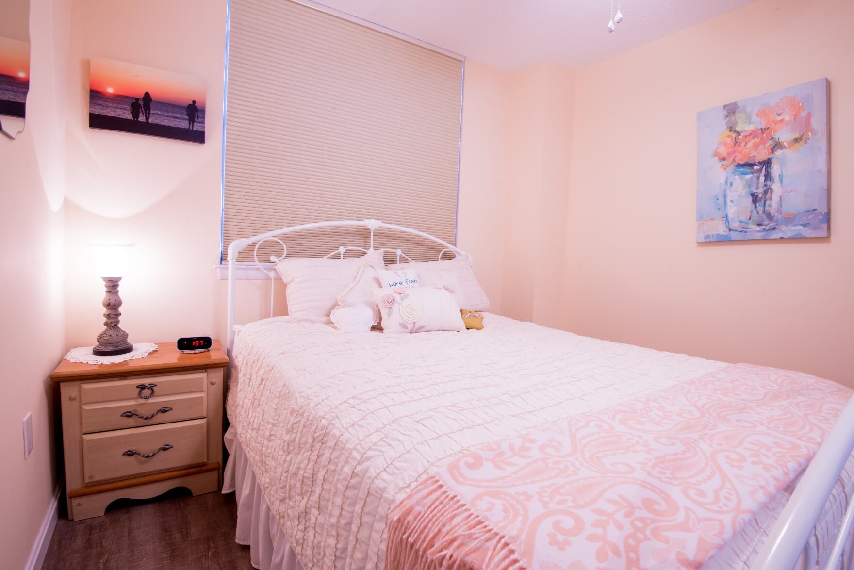 Sea Colony Condo Renovation Bethany Beach, DE Peach Color Bedroom with Dark Wood Floor and Light Wood Night Stand